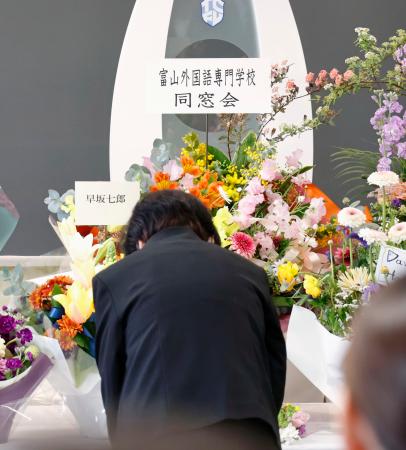 富山外国語専門学校で開かれた追悼の集いで献花するニュージーランド地震犠牲者の遺族＝２２日午前、富山市