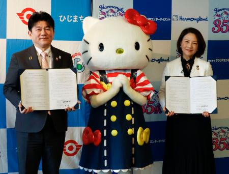 連携協定を締結し、ハローキティと写真に納まるサンリオエンターテイメントの小巻亜矢社長（右）と大分県日出町の安部徹也町長＝２２日午後、日出町