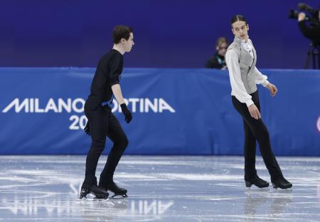 フィギュアスケート男子フリーの演技を前に、ウオームアップするロシア出身のAINのピョートル・グメニク(右)とウクライナのキリロ・マルサク=13日、イタリア・ミラノ(共同)