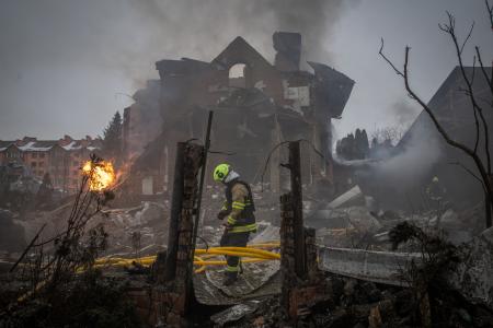 ２２日、ロシアの攻撃があったウクライナ首都キーウ近郊で緊急対応に当たる隊員。ミサイルや無人機攻撃が相次いでいる（ゲッティ＝共同）