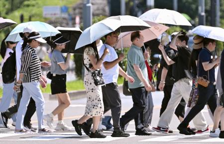 昨年６月、強い日差しに日傘を差す人たち＝東京都内