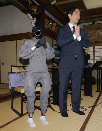仏教経典を学習した生成ＡＩを搭載した人型ロボット「ブッダロイド」と、開発した京都大の熊谷誠慈教授＝２４日午後、京都市東山区