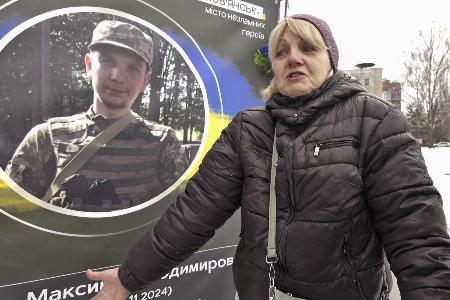 息子の遺影の前で話すナタリア・ネフョードワさん。ロシアのウクライナ侵攻開始から24日で4年となった=23日、ウクライナ・スラビャンスク(共同)