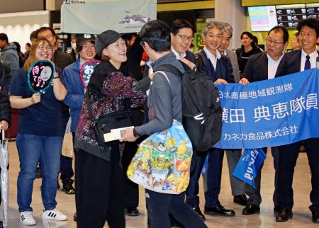 成田空港に到着し家族らと再会する南極観測隊の隊員（手前右）＝２５日午前