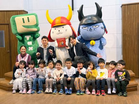 絵本「ひこにゃんえほん」の特別編のお披露目式で、園児らと写真に納まるひこにゃん（奥中央）＝２６日、滋賀県彦根市