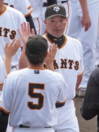 那覇キャンプを打ち上げ、ナインとタッチを交わす巨人・阿部監督＝那覇