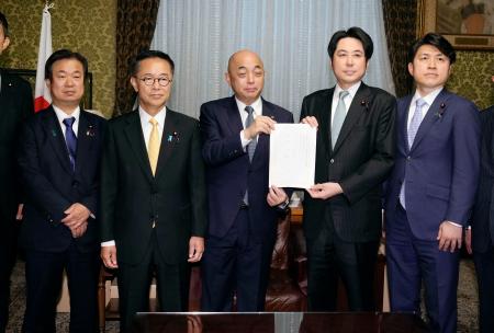 衆院の築山信彦事務総長（中央）に企業・団体献金の規制を強化する政治資金規正法改正案を提出する中道改革連合と国民民主党の議員＝２日午後、国会