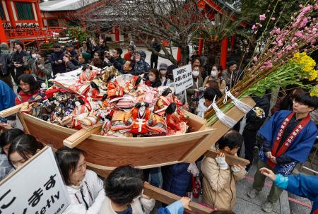 淡嶋神社の「ひな流し」で、小舟に乗せられ、参拝客らに担がれるひな人形＝３日午後、和歌山市