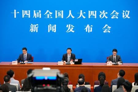 記者会見する中国の全国人民代表大会の婁勤倹報道官（中央）＝４日、北京の人民大会堂（共同）