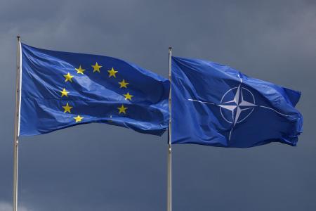欧州連合（ＥＵ）＝左＝と北大西洋条約機構（ＮＡＴＯ）の旗＝２０２５年７月、ベルリン（ロイター＝共同）