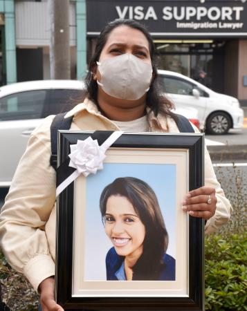 名古屋入管前でウィシュマ・サンダマリさんの遺影を抱える妹のポールニマさん＝６日午前、名古屋市