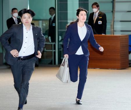 閣議に遅れ、走って首相官邸に入る小野田経済安保相(右)=6日午前