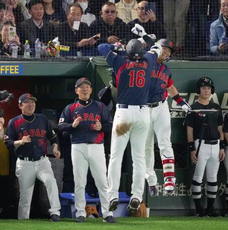 ２回、先制の満塁本塁打を放った大谷（１６）を跳び上がって迎える鈴木。左から２人目は井端監督＝東京ドーム
