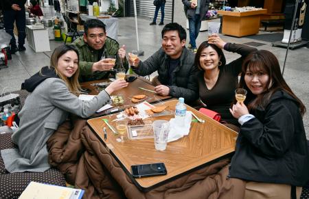 土佐の「おきゃく」が始まり、商店街に設けられた座敷で乾杯する人たち＝７日午後、高知市