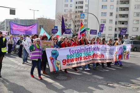 ８日、ベルリンで行進する国際女性デーのデモ参加者（共同）