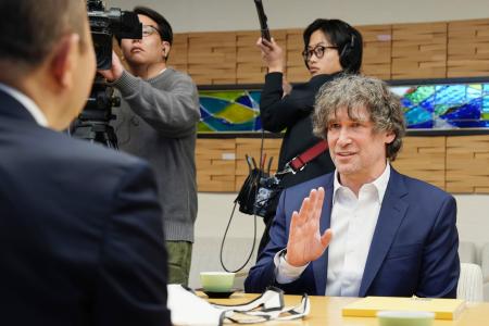 長崎市役所で鈴木史朗市長（左）と面会する米シカゴ大のダニエル・ホルツ教授＝９日午前