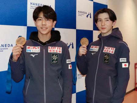 　羽田空港でメダルを掲げるフィギュアスケート男子の中田璃士（右）と西野太翔＝９日