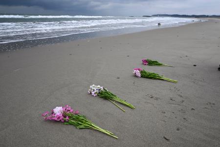 福島県浪江町請戸地区の海岸に手向けられた花束＝１０日午前