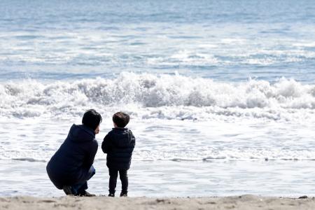 東日本大震災から１５年、仙台市若林区荒浜地区の海岸に訪れた、同市在住の川内史乃さん（左、４０）と息子の成ちゃん（３）。史乃さんは「このなかに沈んでしまった人がいるんだよ」と息子に語りかけ、「どんなことがあったのか胸にとどめておいてほしい」と願った＝１１日午前１０時２３分