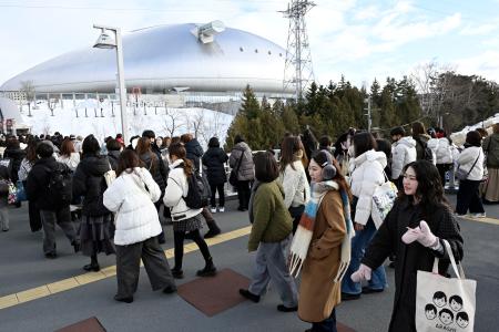 アイドルグループ「嵐」の公演が行われる札幌市の大和ハウスプレミストドームに向かう人たち=13日午後