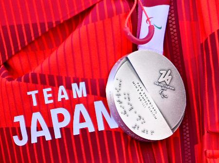 点字が刻まれたミラノ・コルティナ冬季パラリンピックのメダル＝１３日、イタリア・コルティナダンペッツォ（共同）