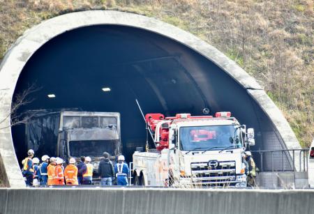 新名神高速道路下り線の野登トンネル内で発生した事故現場周辺を調べる捜査員＝２０日午前９時１５分、三重県亀山市