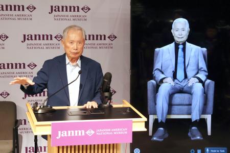 １９日、自身の体験を対話形式で伝える機器の隣で、記者会見するジョージ・タケイさん＝米ロサンゼルス（共同）