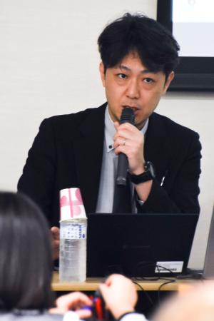 講演する共同通信政治部の福田公則記者＝２０日午後、横浜市（共同）