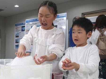 南極について学ぶイベントで、氷に触れる子どもたち=21日午後、広島市中区