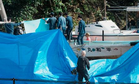 辺野古沖で転覆した船「平和丸」を実況見分する海保の係官ら。奥は「不屈」＝２２日午前、沖縄県名護市