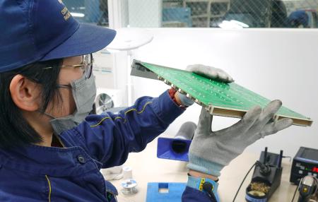 修繕した電子基板をチェックするJR東海の社員=13日、浜松市