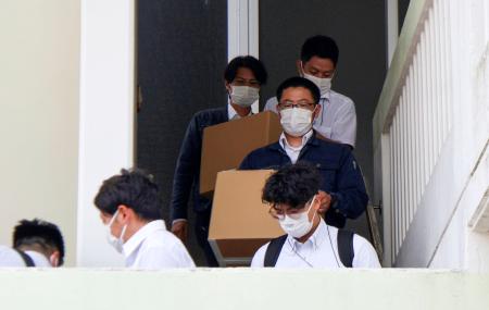 辺野古沖の転覆事故で死亡した船長の関係先から段ボール箱を運び出す海保の職員ら＝２５日午後、沖縄県南城市