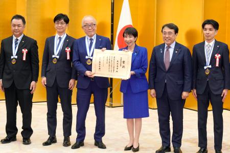 第１０回「ものづくり日本大賞」の表彰式で、高市首相（中央右）と記念写真に納まる福井経編興業の高木義秀社長（同左）ら。右から２人目は赤沢経産相＝２５日午後、首相官邸