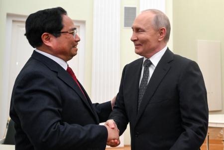 握手するロシアのプーチン大統領（右）とベトナムのファム・ミン・チン首相＝２５日、モスクワ（タス＝共同）