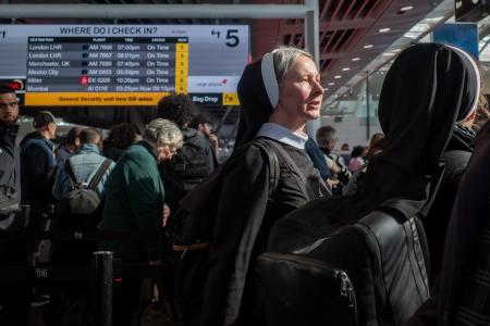 ２５日、米ニューヨークのケネディ国際空港で、チェックインのための列で待つ人たち（ゲッティ＝共同）