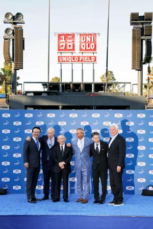 記念写真に納まるユニクロの柳井正会長（左から３人目）、ドジャースのロバーツ監督（同４人目）ら＝２５日、米ロサンゼルス（共同）