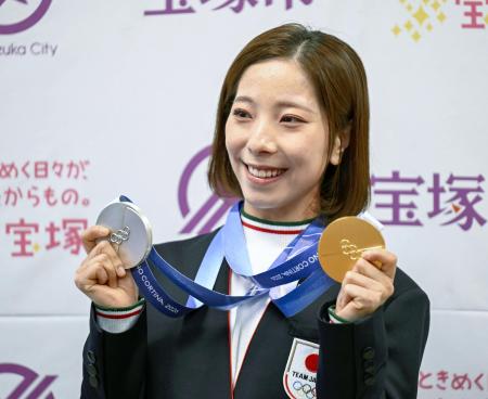 ２日、兵庫県宝塚市役所で、メダルを手に笑顔を見せる「りくりゅう」ペアの三浦璃来選手