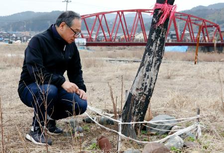 焼け焦げた柿の木を見つめる畠中陽一さん＝２５日、石川県輪島市