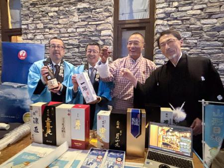 山形県の酒を手にする（右から）小野啓一駐インド大使、ブータンのトブゲイ首相ら＝２７日、ティンプー（共同）