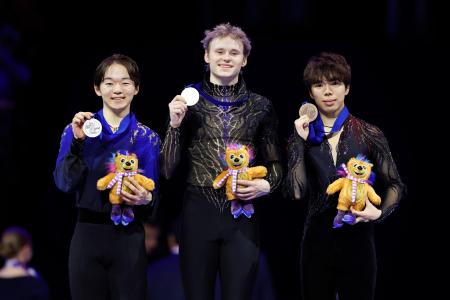 男子の表彰式でメダルを掲げる（左から）２位の鍵山優真、優勝のイリア・マリニン、３位の佐藤駿＝プラハ（共同）
