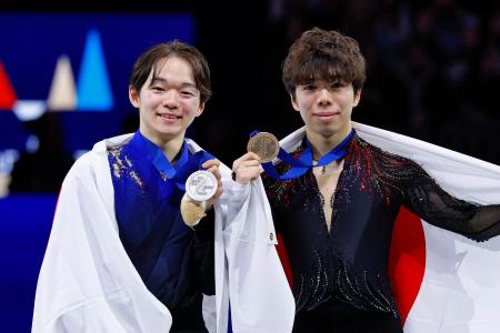 男子の表彰式でメダルを掲げる２位の鍵山優真（左）と３位の佐藤駿＝プラハ（共同）