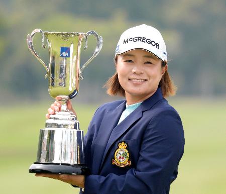通算１３アンダーで優勝し、トロフィーを手に笑顔の永峰咲希＝ＵＭＫＣＣ