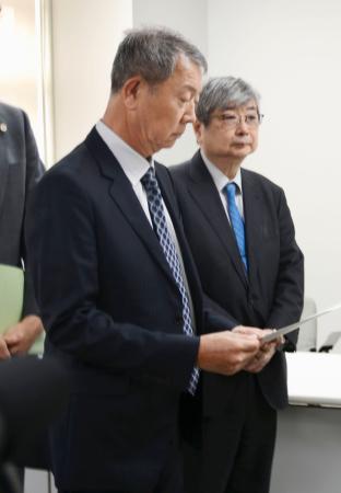 東京都から調査報告書を受け取った江蔵智さん（手前）＝３０日午前、都庁