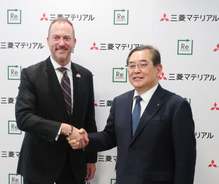 記者会見で握手する三菱マテリアルの田中徹也社長(右)とリエレメントのカーク・テイラーCFO=31日午後、東京都千代田区