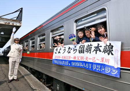 JR北海道の留萌線が運行最終日を迎え、石狩沼田駅を発車した列車から手を振る乗客=31日午前、北海道沼田町