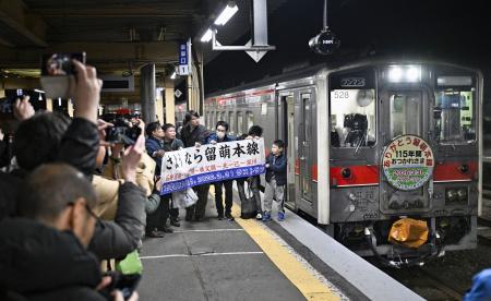 ＪＲ留萌線の深川駅に到着した最終列車を囲む人たち＝３１日午後１０時４分、北海道深川市