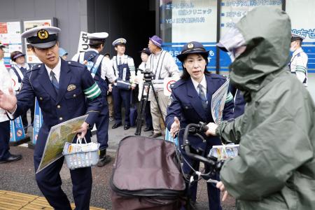 自転車の青切符制度が始まり、交通ルールを指導する警察官＝１日午前、東京都北区