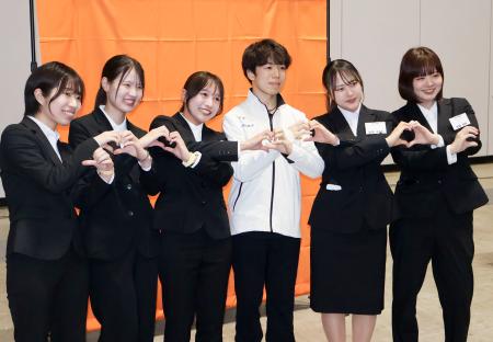 所属先の入社式にゲスト参加し、新入社員と写真に納まるフィギュアスケート男子の佐藤駿（右から３人目）＝１日、横浜市