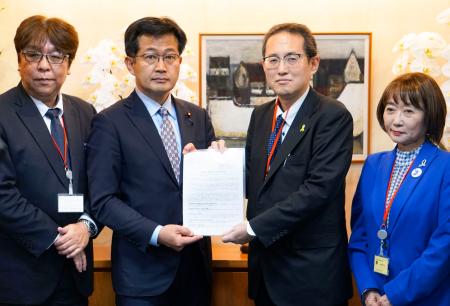 仁木博文厚労副大臣(中央左)に要望書を手渡す、全国がん患者団体連合会の天野慎介理事長(同右)=1日午後、厚労省