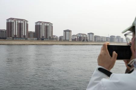 鴨緑江を挟んで中国の対岸にある北朝鮮の新義州周辺＝３月、中国遼寧省丹東から撮影（共同）
